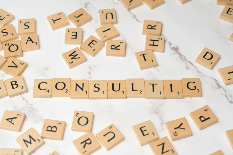 the word consulting spelled by scrabble letters on a marble surface