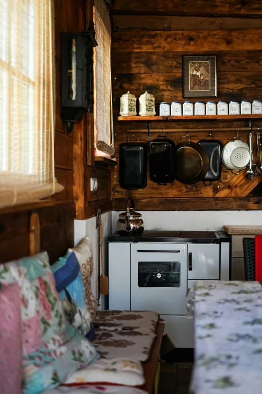 a kitchen with stove, sink and wooden shelves