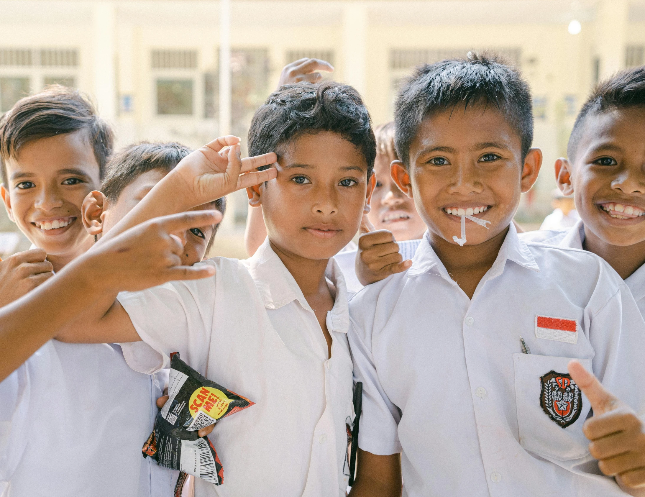 three boys with white tshirts are making the finger sign with their fingers