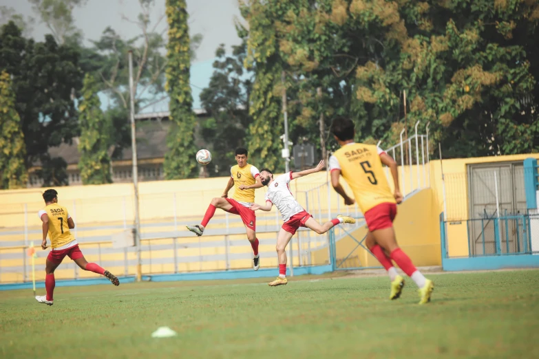 three men are playing soccer on the grass