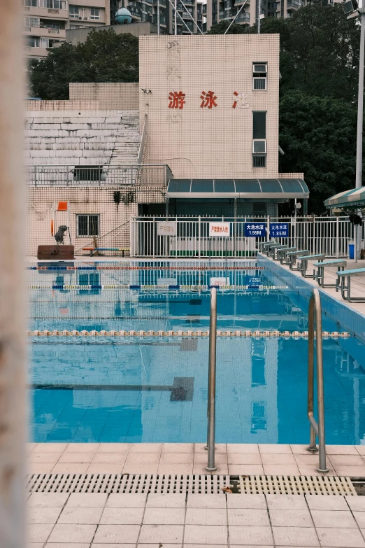 the empty swimming pool in the city, with a few swimmers