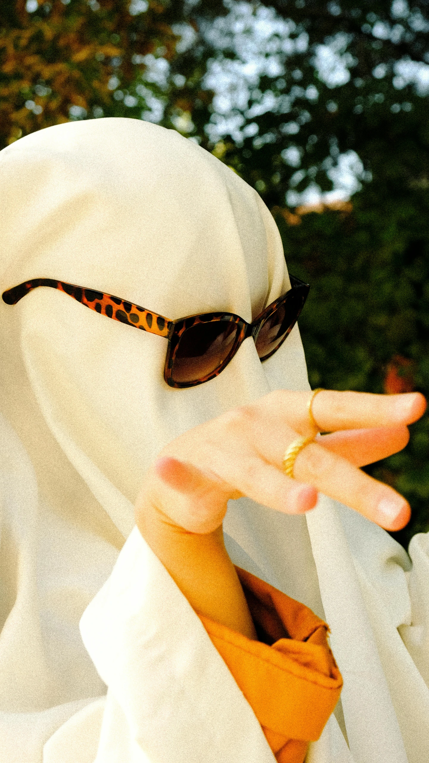 a woman wearing sunglasses in front of a white bird