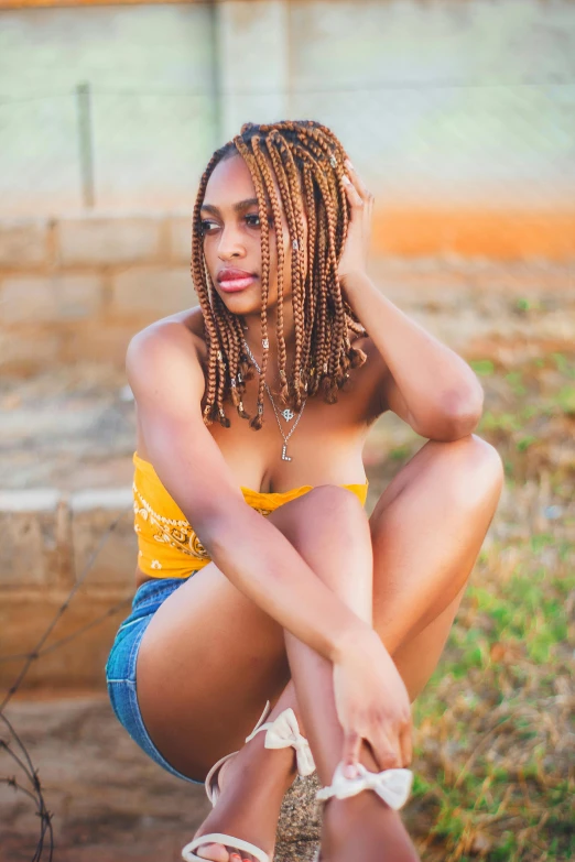 a woman sitting down in shorts and yellow top