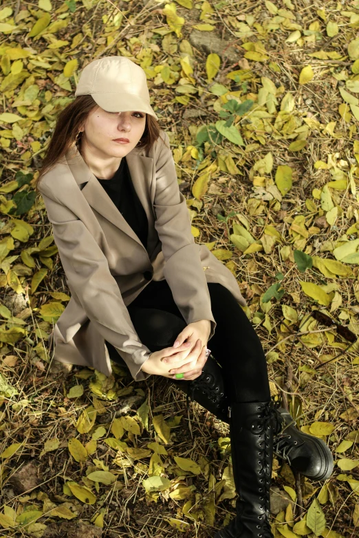 a woman sits in a field full of leaves