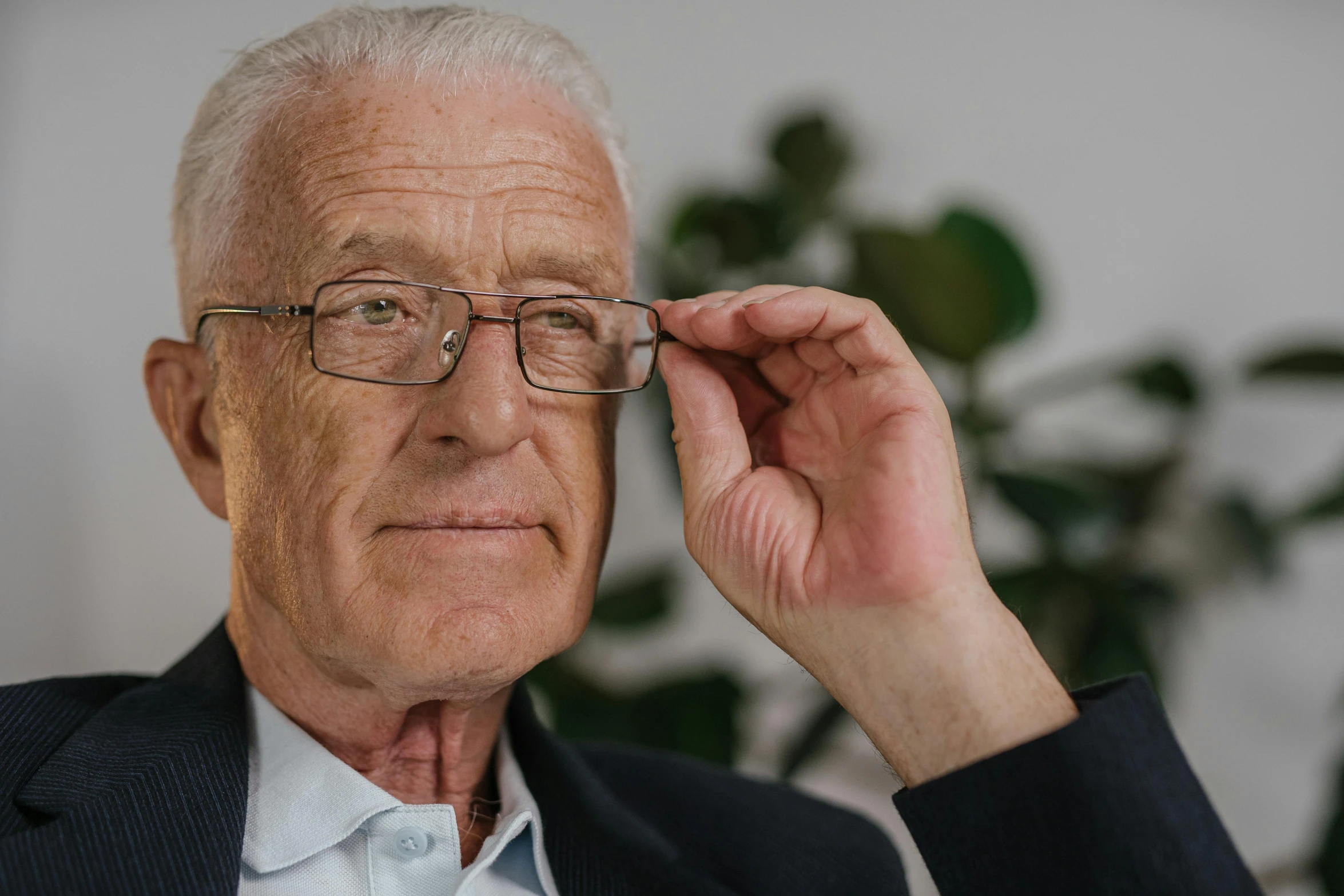 an older gentleman is posing with his glasses on