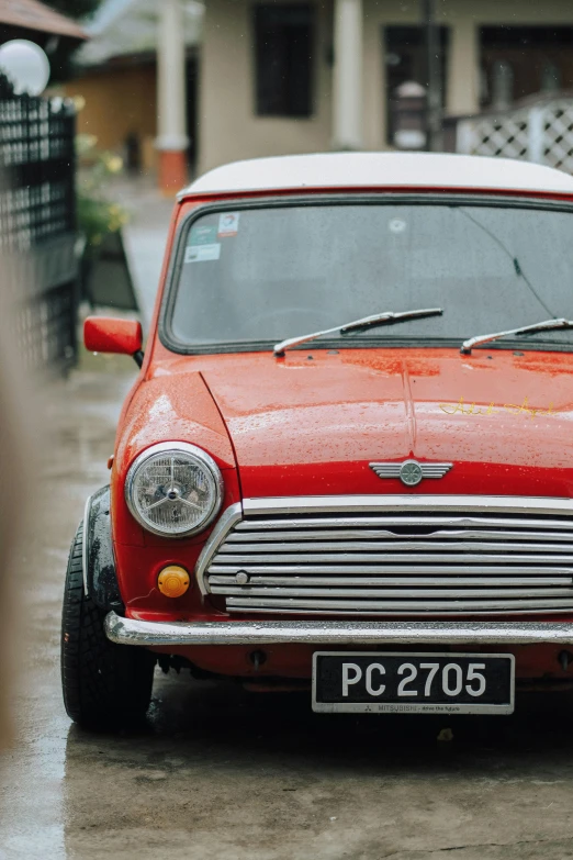 an old - fashioned mini, in the rain, parked