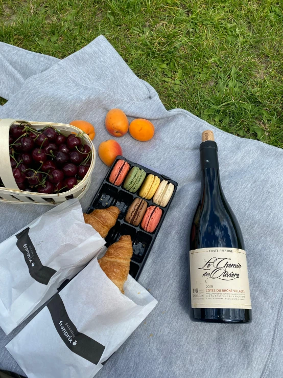 some food and champagne are set on a towel