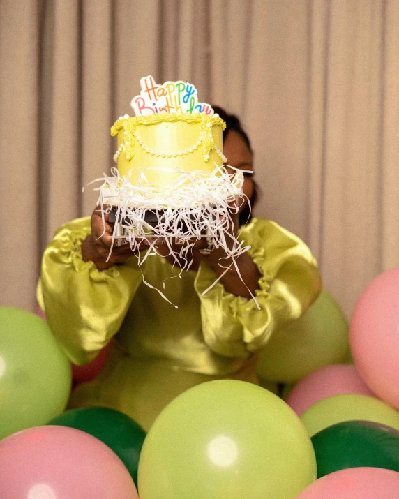 an african american girl is holding up a cake