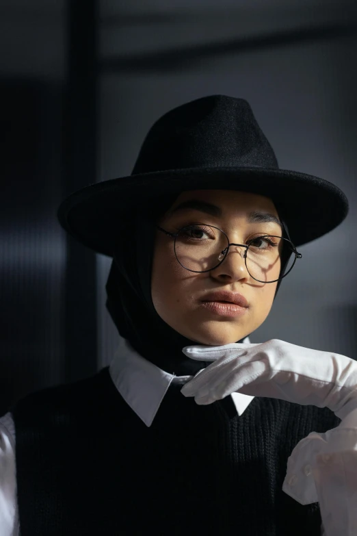 a woman in a hat and eyeglasses in a room