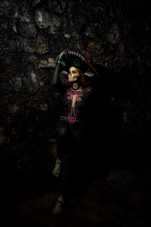 woman sitting on rocks holding a fan, arms folded up