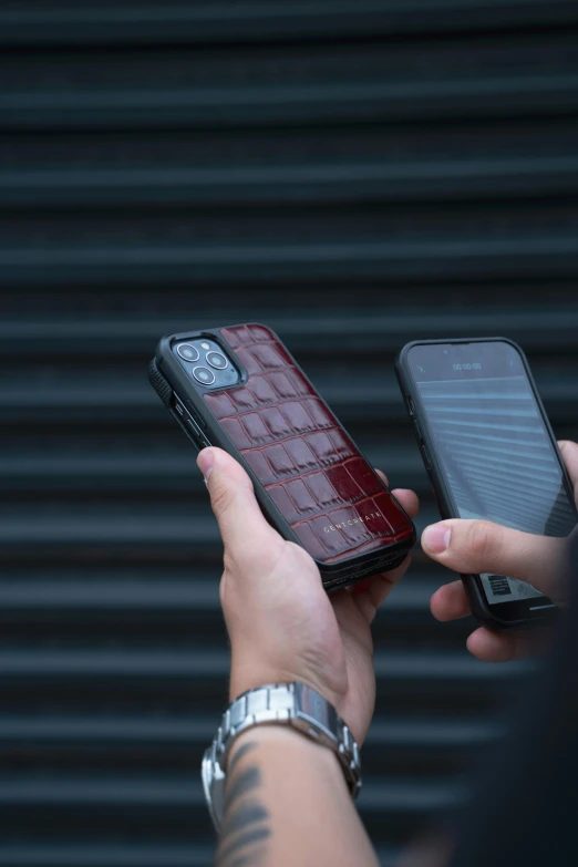 someone holds up their cell phone with a brick case