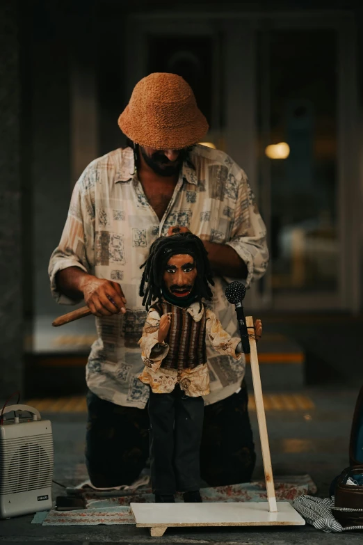 a man wearing a straw hat standing next to a display of figurines