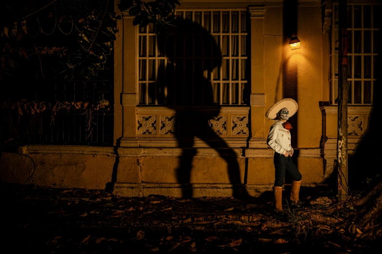 shadow of person with an umbrella standing near building