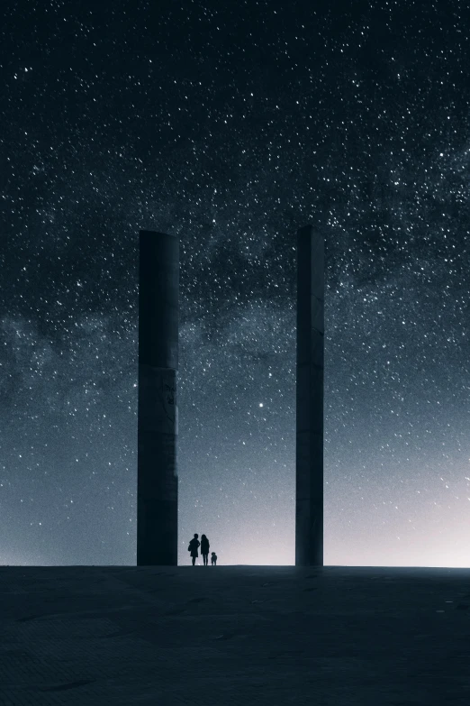 a couple standing in the dark with two tall towers