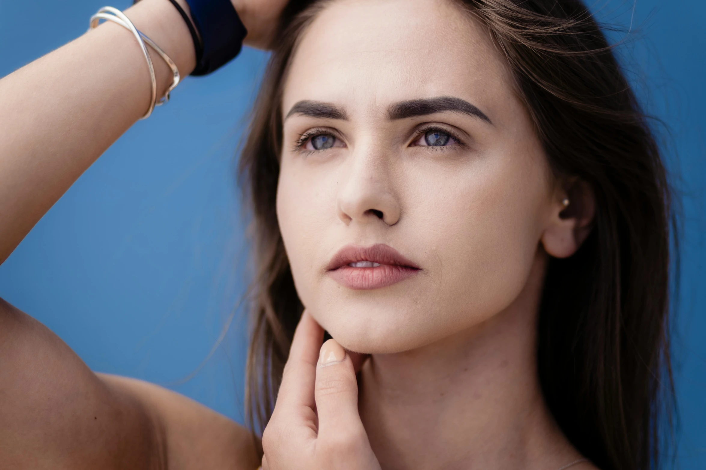 a woman is posing with her hand over her shoulder