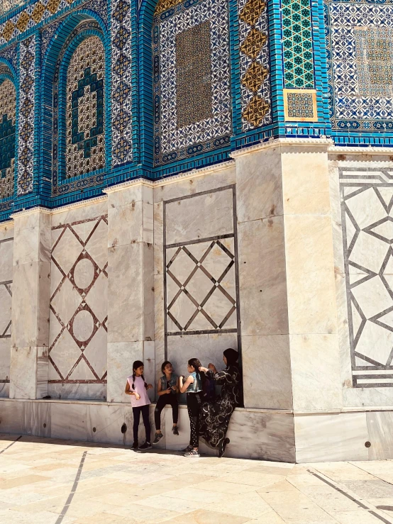 group of people standing on the side of a building