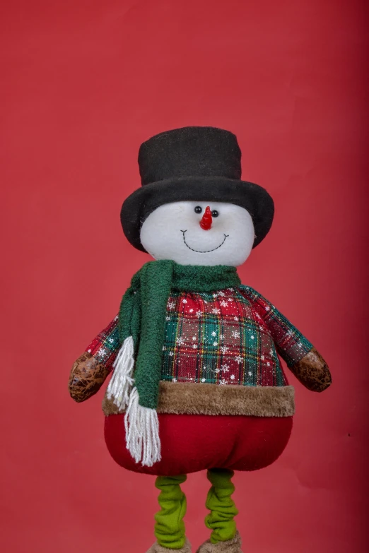 a snowman standing on top of a stool wearing a hat and scarf