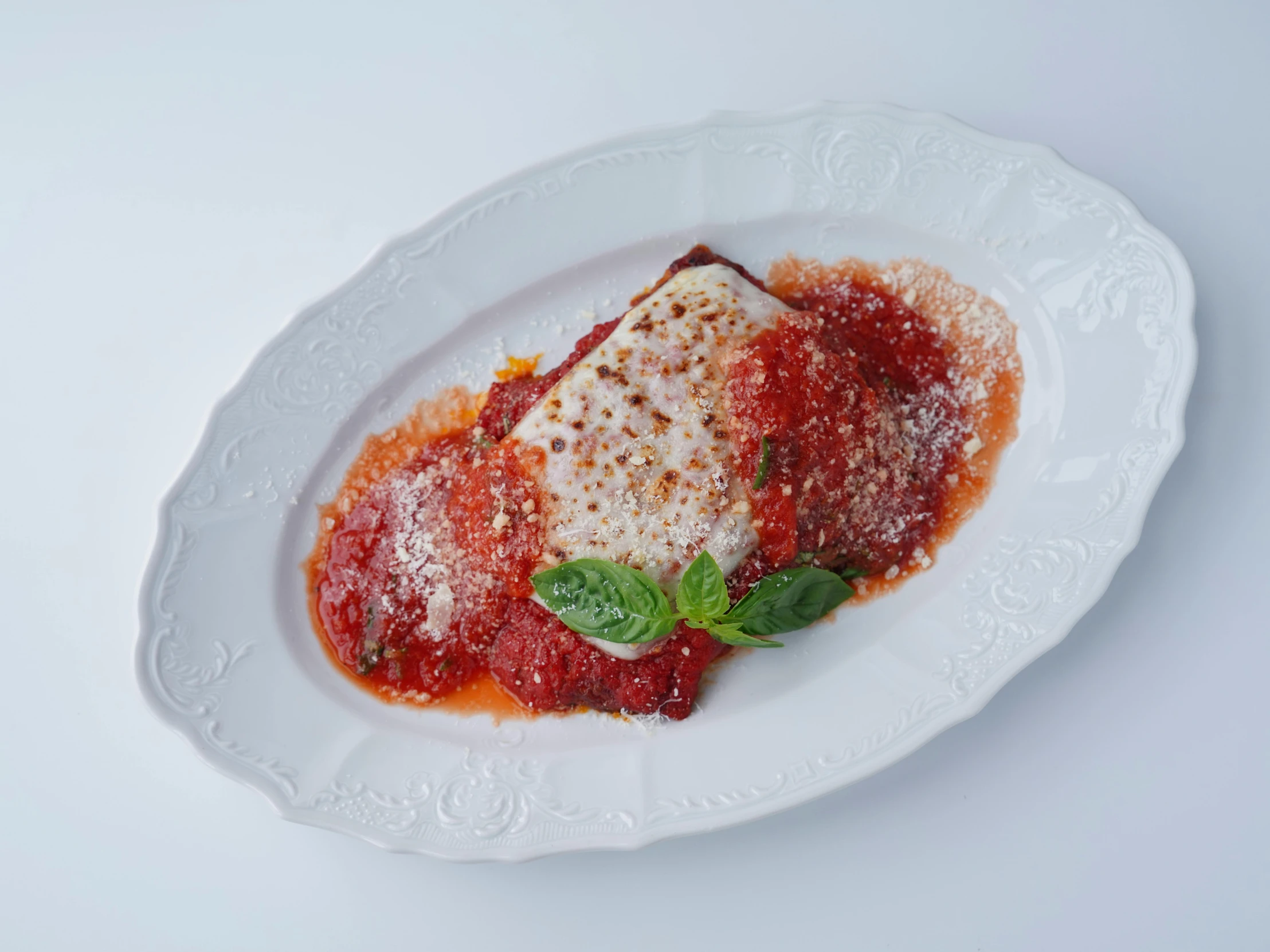 white plate of food containing sauce and greens