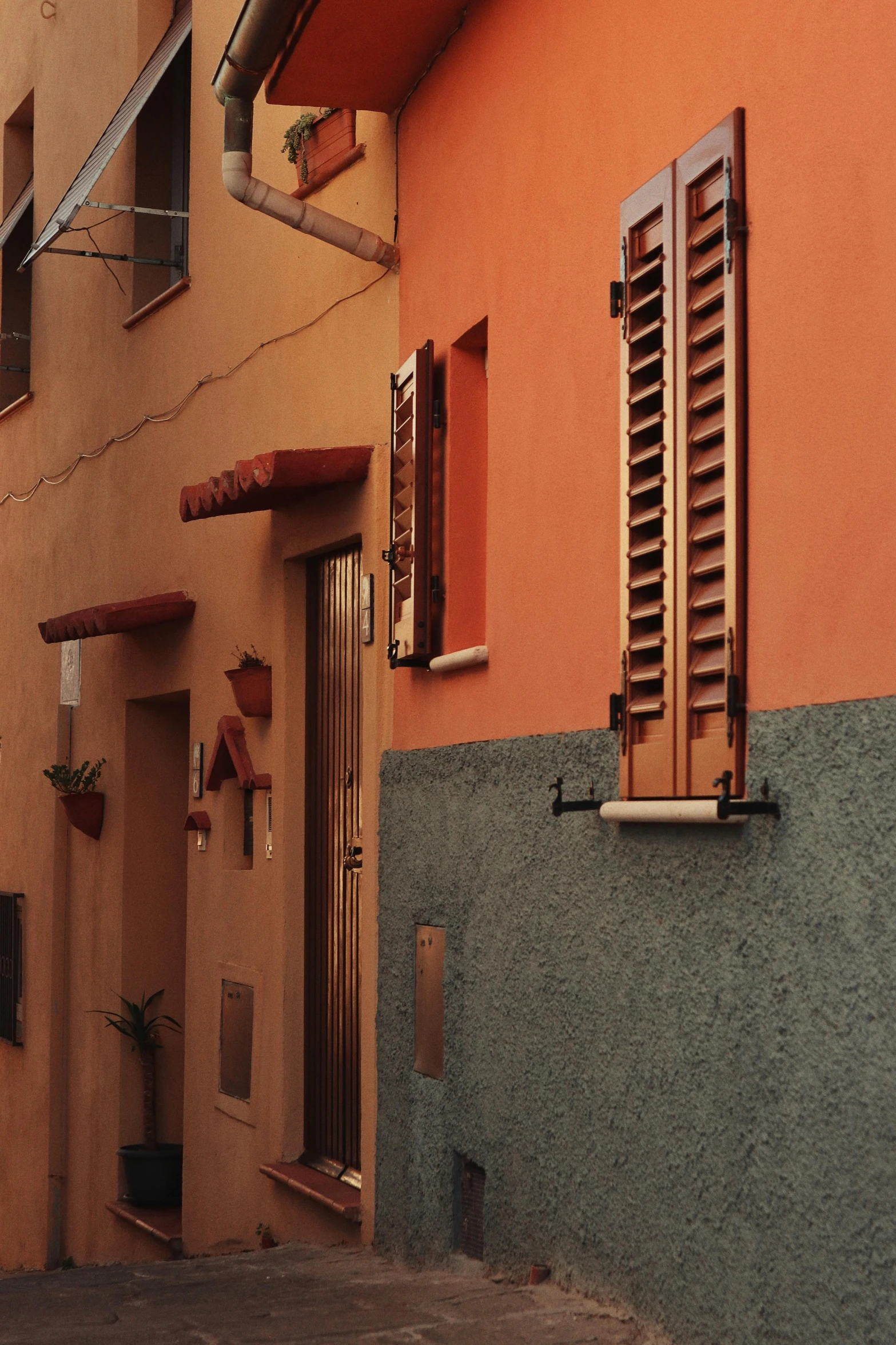 some brown buildings and windows are on the sidewalk