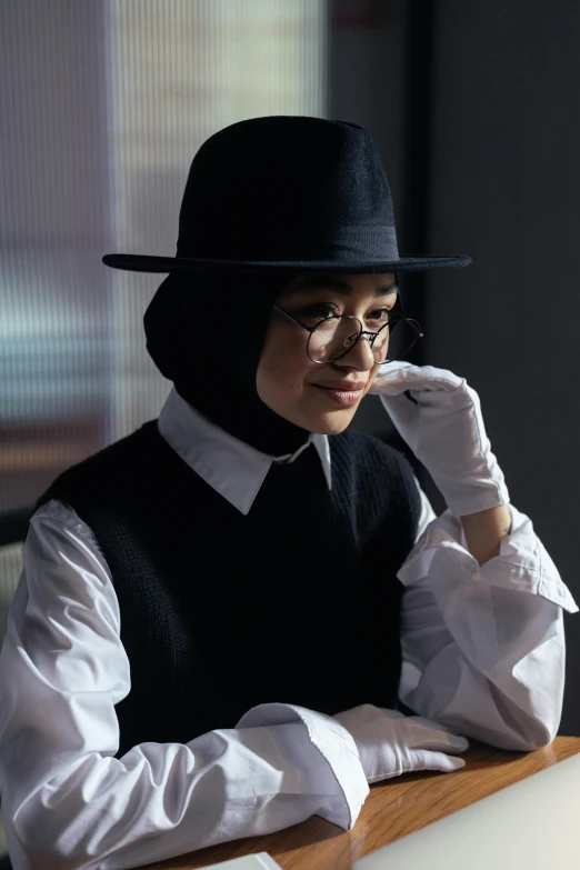 a woman in a hat sitting at a table