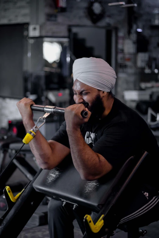 a man is sitting in a chair and wearing a turban while playing the trumpet