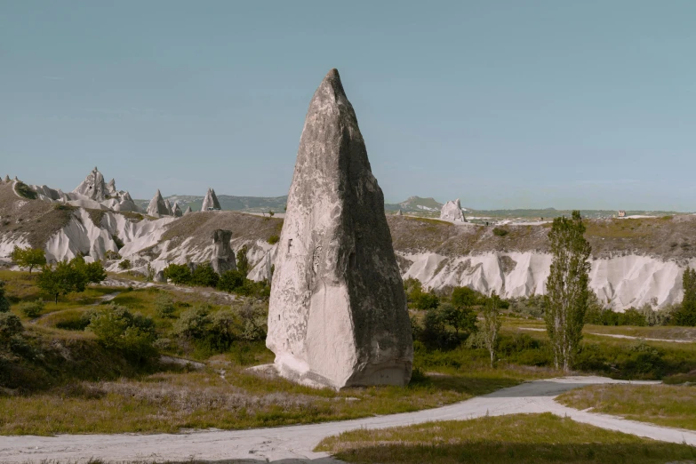 a large rock sitting on top of a lush green field