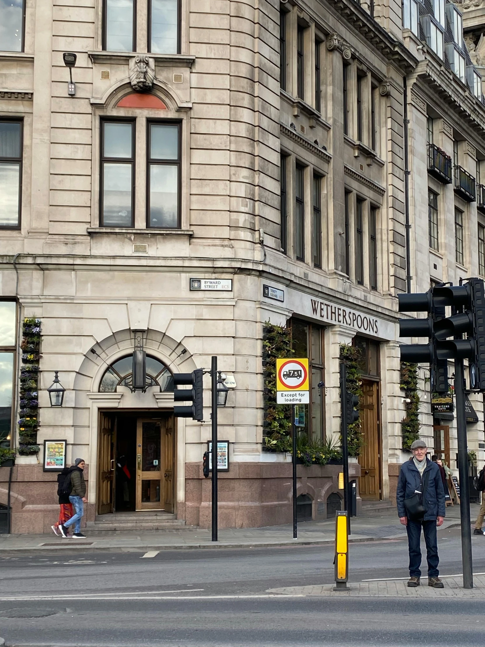 people stand in the street near some buildings