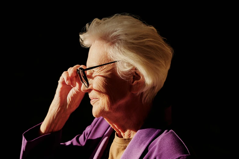 an elderly woman talking on the phone in the dark