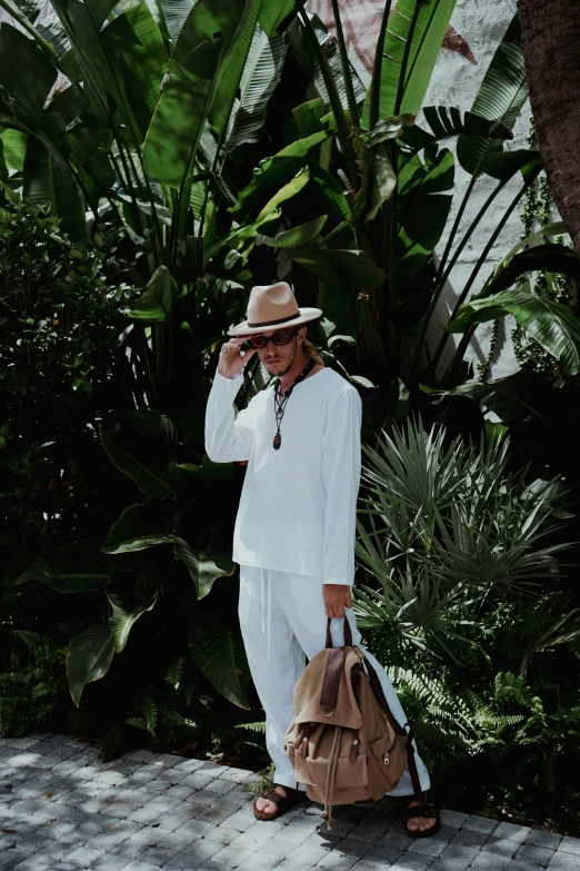 a person carrying a bag next to some plants