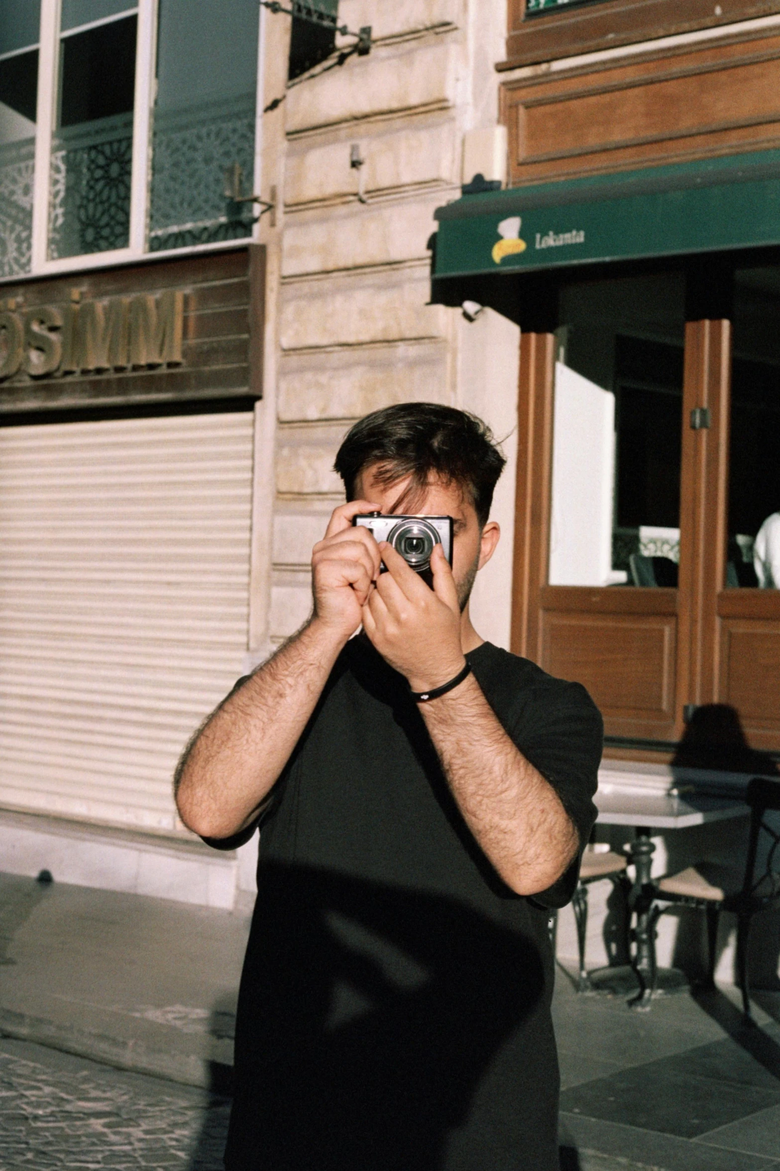 a man taking a picture with a camera outside