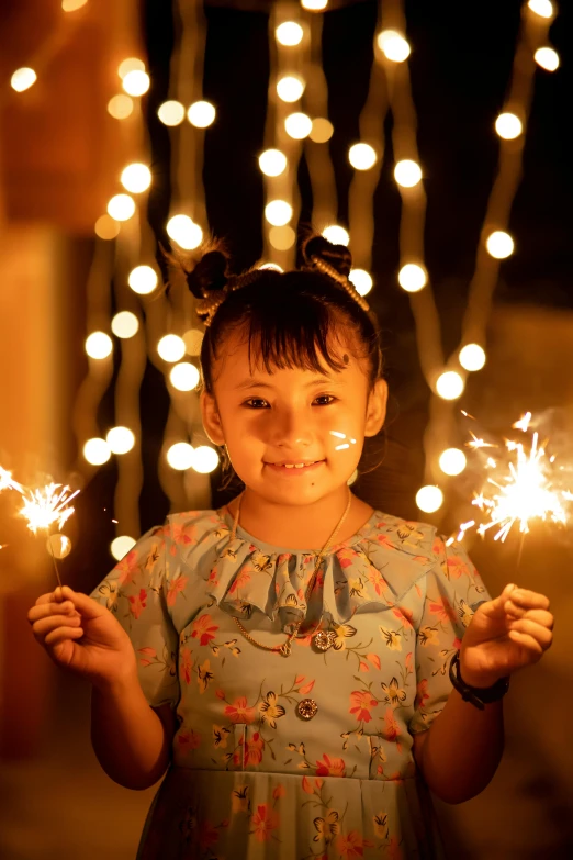 a girl holding sparklers in her hands at night