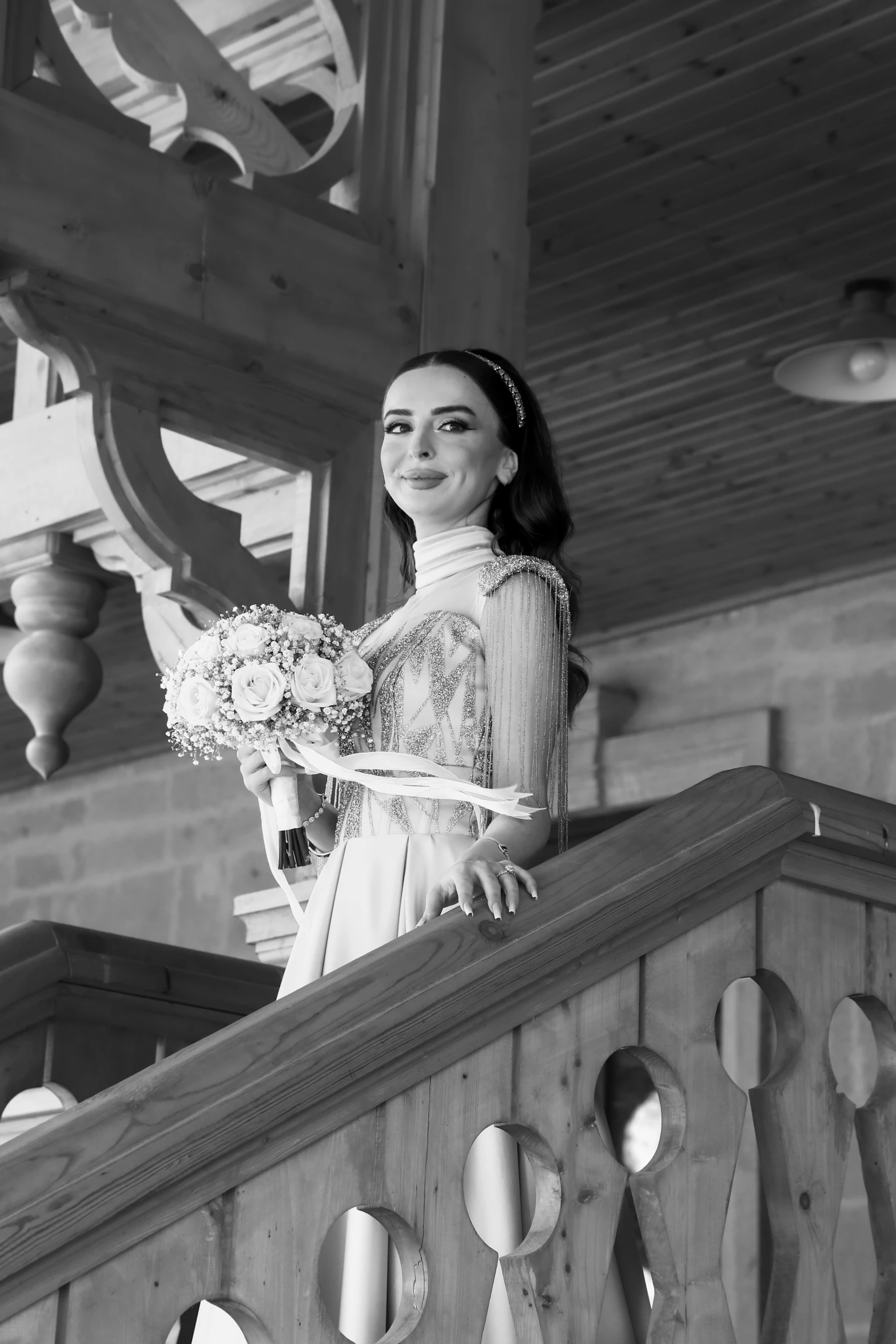 a woman wearing a wedding dress standing on top of stairs