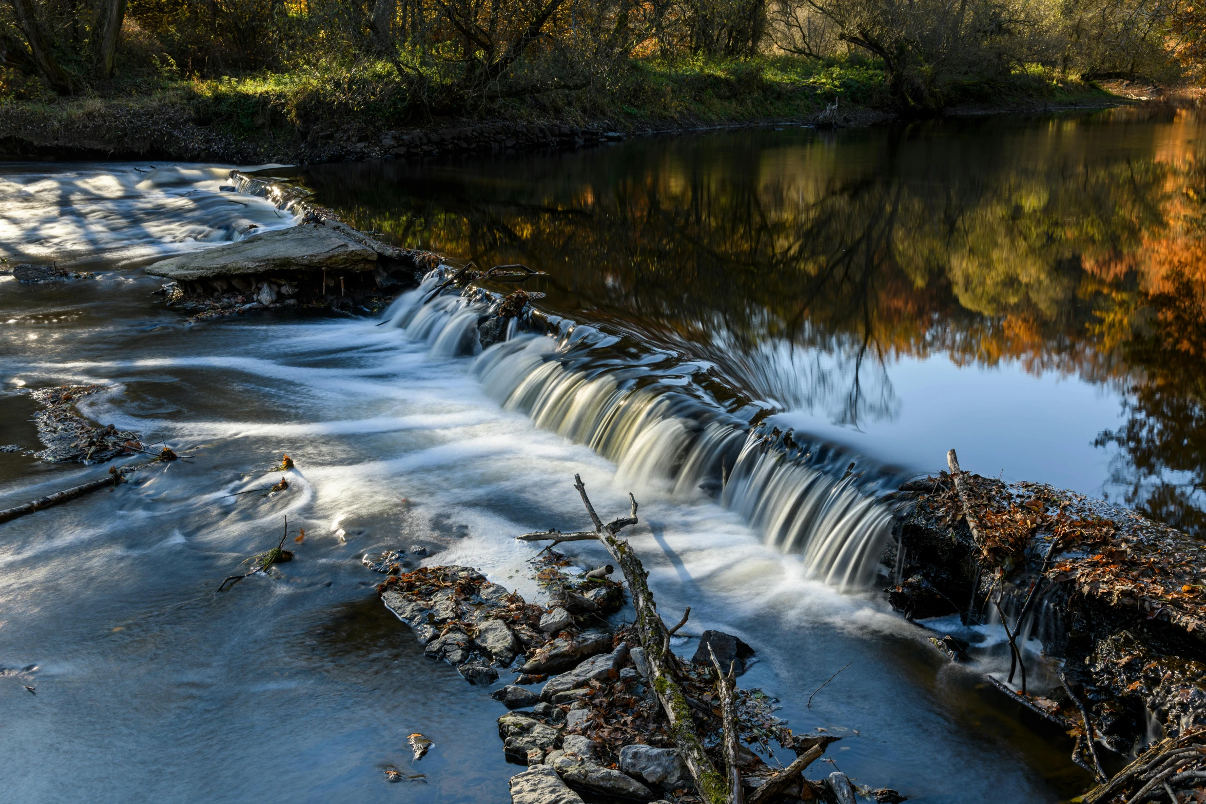 an autumn scene with the water rushing towards the shore