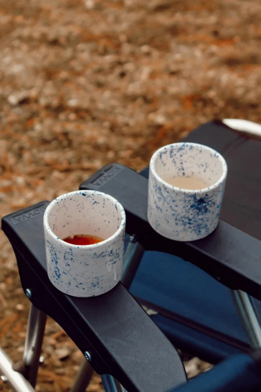 two empty cups with red liquid are on a chair