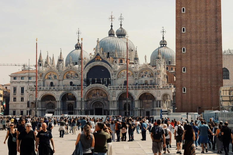 a crowd of people walking in front of a very old building