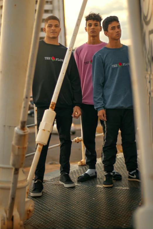 three young men are standing on a ferry