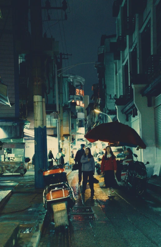 two people walk on the street as it is night