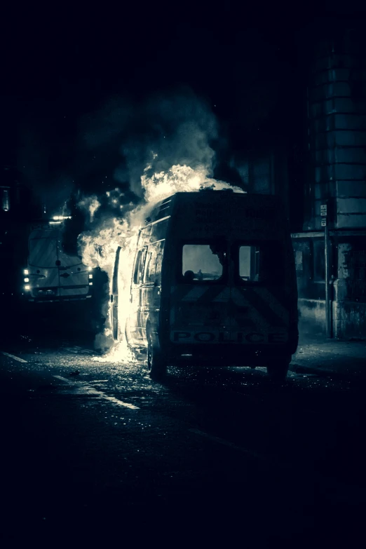 black and white image of fire burning out of a bus