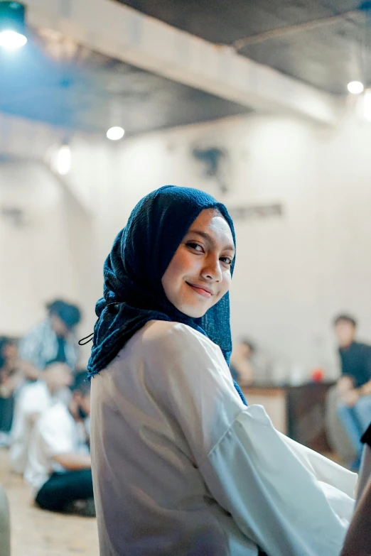 a woman with a headscarf in the middle of a room