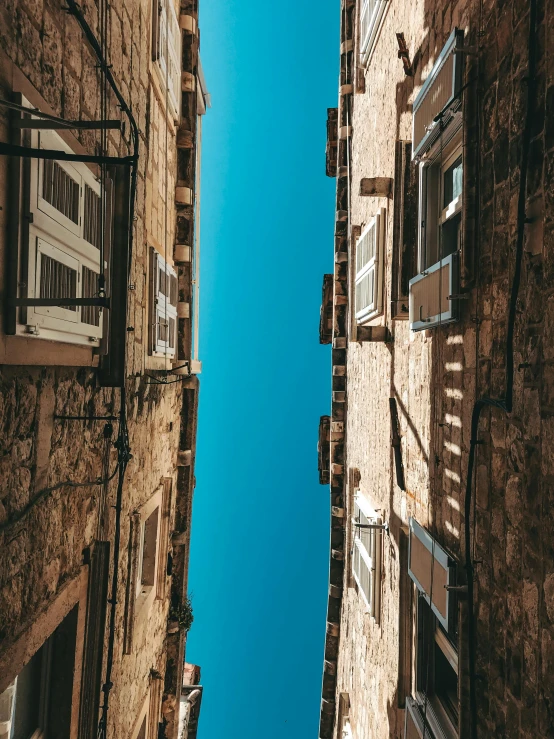 view looking up at two narrow buildings with closed windows