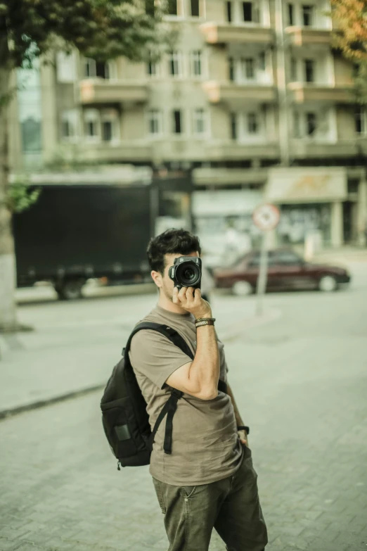 a man talking on a cell phone with a backpack on the street