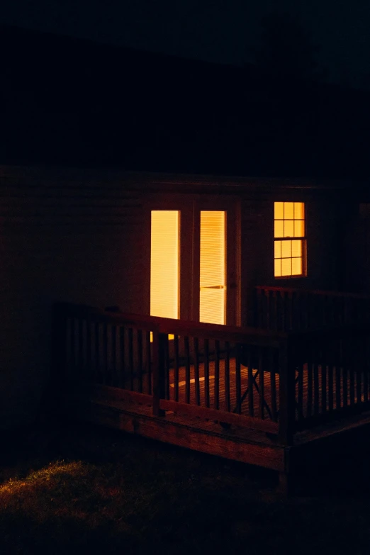 a porch with two doors and windows in a dark night