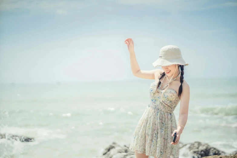 a pretty young woman in a white hat pointing at the water