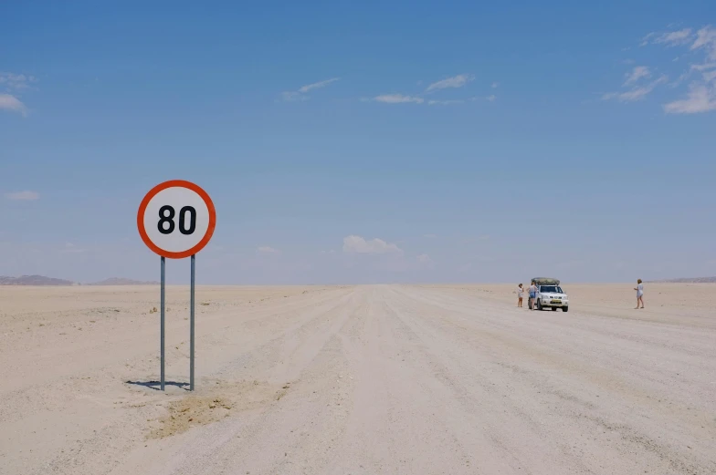 an empty open road with people and a road sign