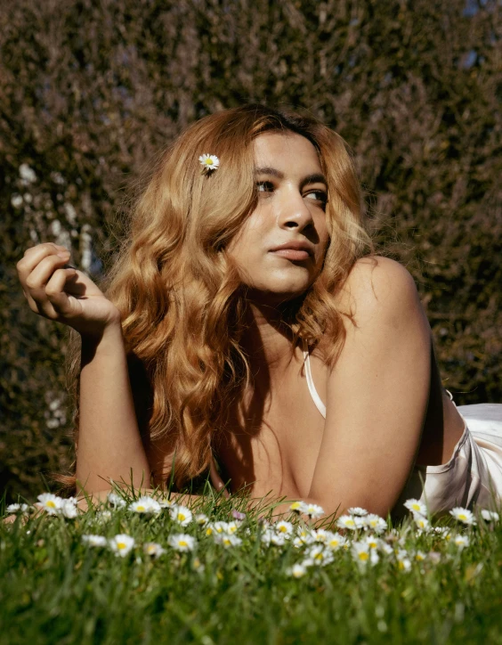 an attractive woman lying on the grass outside