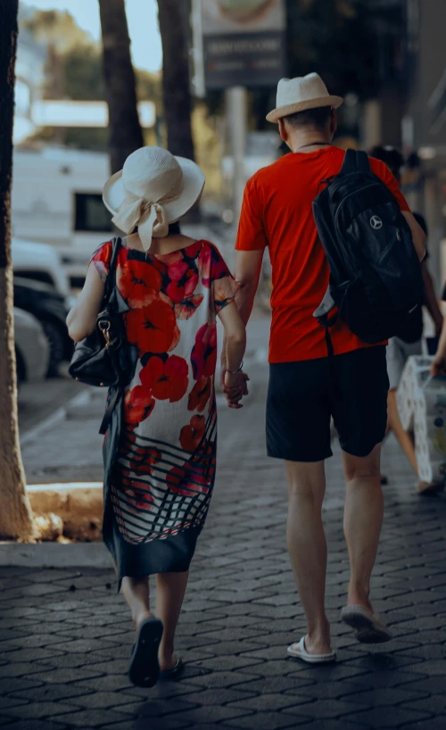 a woman and man walking down the sidewalk together