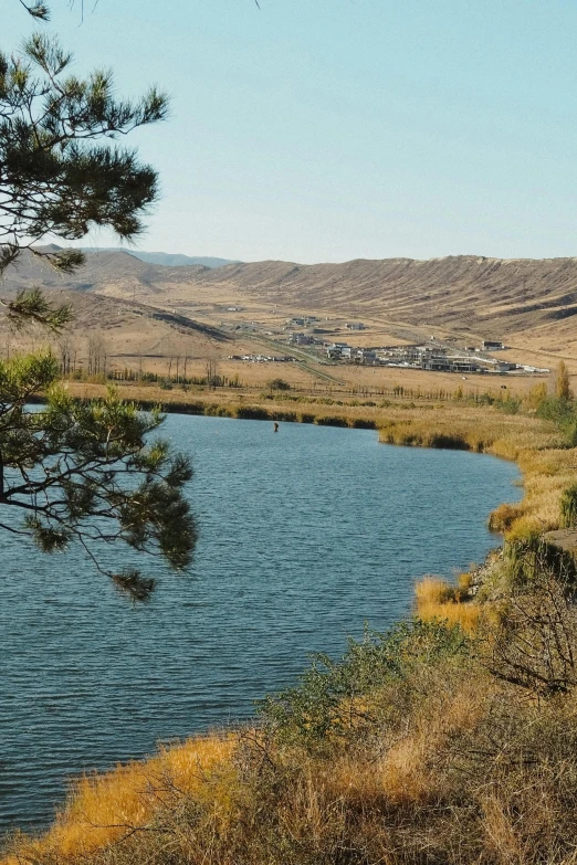 a body of water surrounded by a hill side