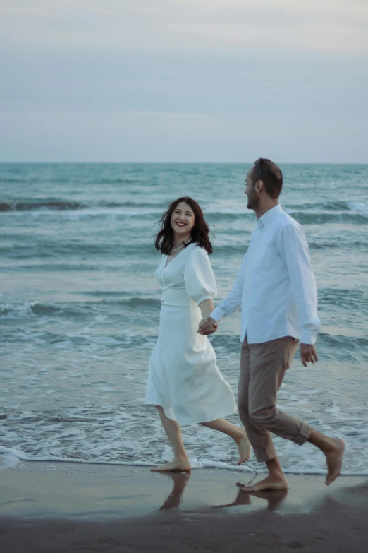 there is a man and woman running along the beach