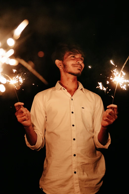 a person holding sparklers in their hands outside