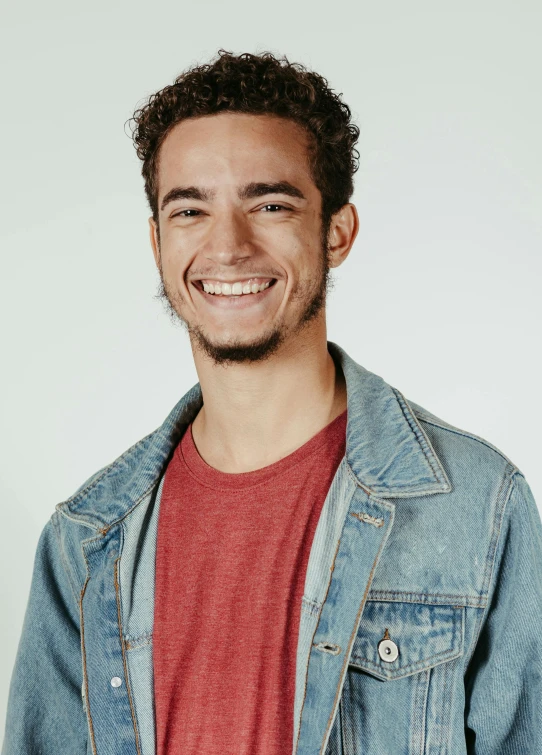 a smiling man is standing against a white background